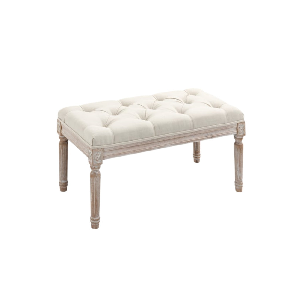 Pouf élégant en velours beige avec piétement en bois blanc sculpté.